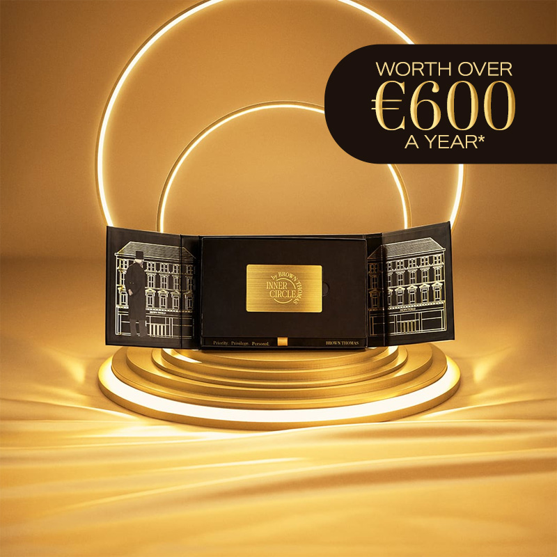 Black box containing a gold membership card displayed surrounded by lights on a gold background.